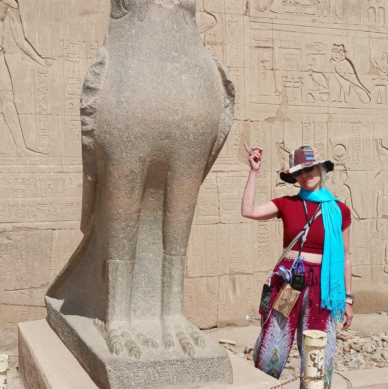 Traveler beside the granite falcon statue at the Temple of Horus in Edfu