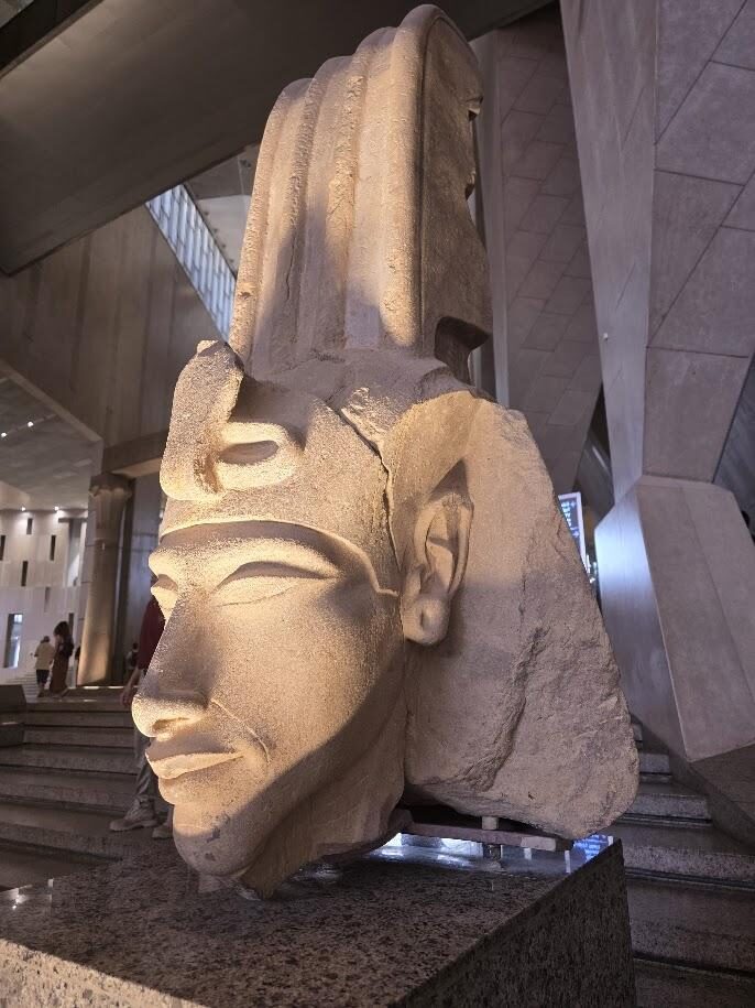Colossal pharaoh head displayed inside a museum hall